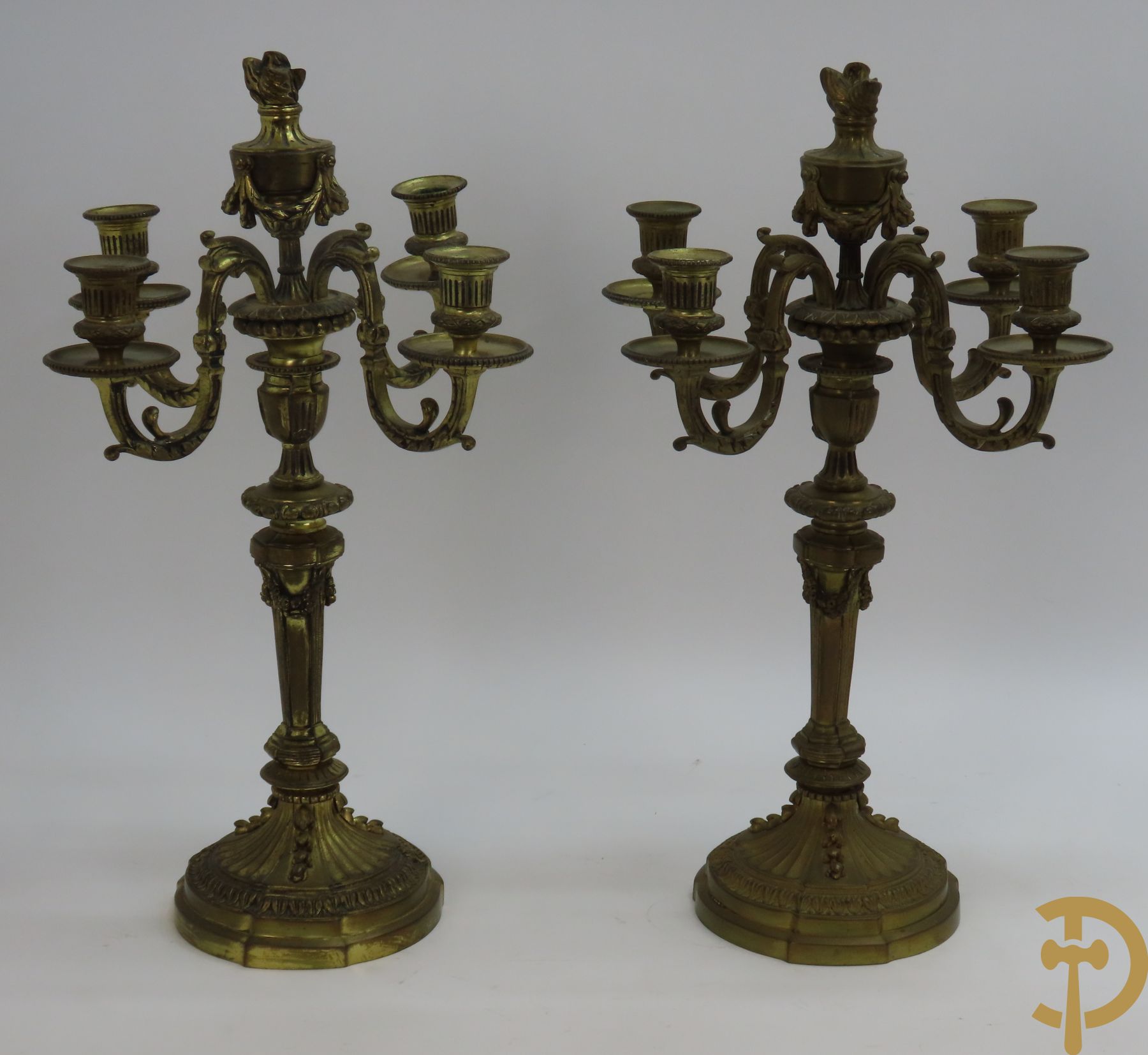 Paar bronzen Louis XVI vierarmige kandelaars bezet met toorts bovenaan