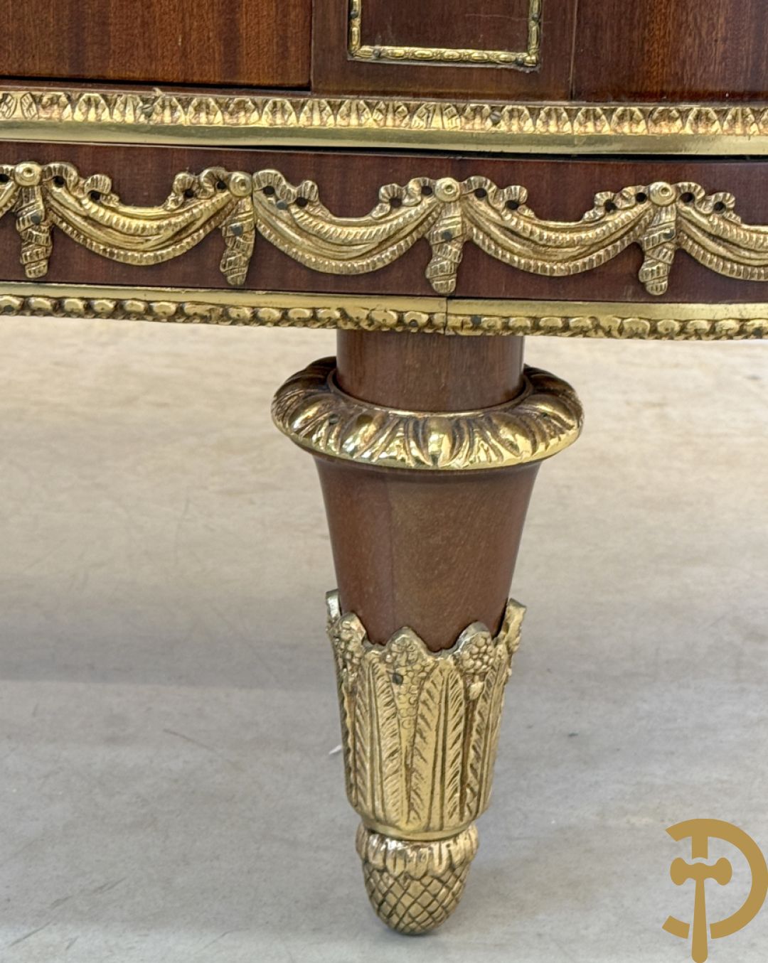 Notelaren vitrine met afgeronde zijkanten, bezet met bronzen plakkettes van dame en cupido