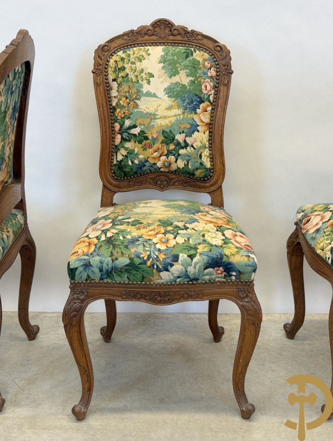 Vier eiken Louis XV stoelen met gebloemde stof en rocailles in de rug, op voluutvormige poten