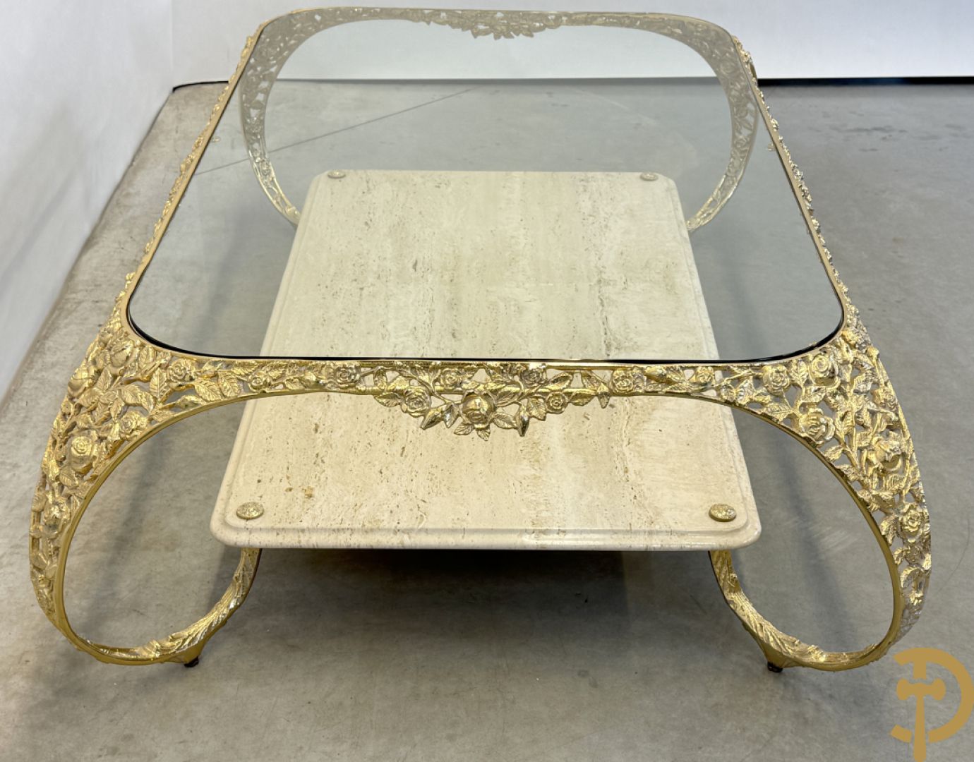 Salontafel met glazen blad op gebogen voluutvormige koperen poten gemaakt van bladranken - onderaan met travertin blad