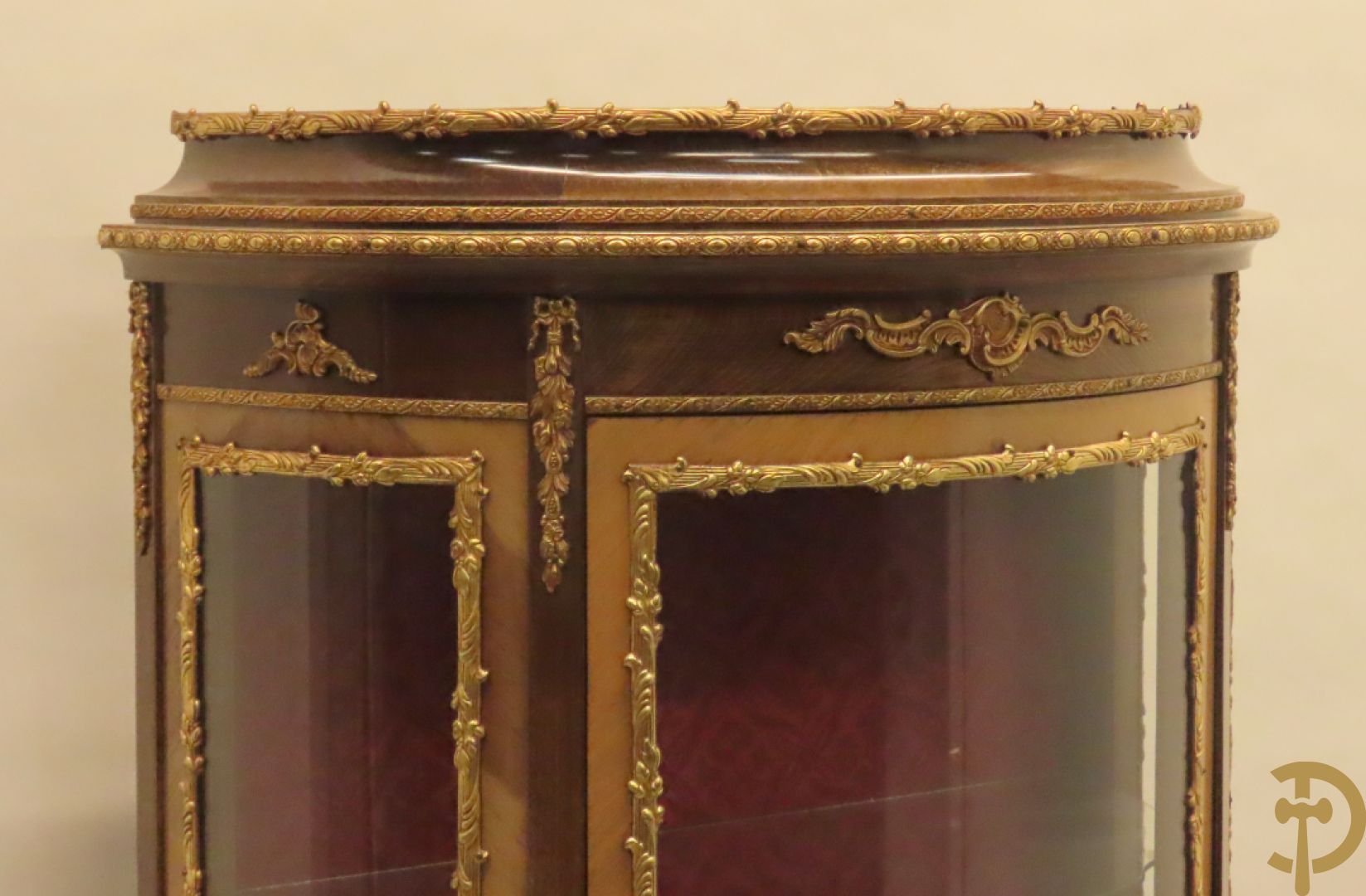 Gebogen notelaren vitrine met bronsbeslag en geanimeerd romantisch tafereel onderaan