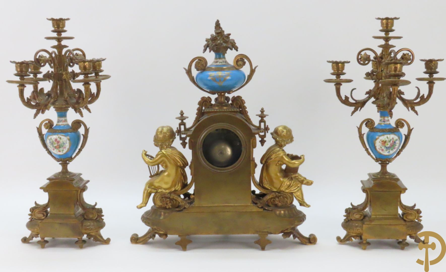 Driedelige bronzen garnituur bezet met Sèvres porselein bestaande uit pendule geflankeerd door paar cupido