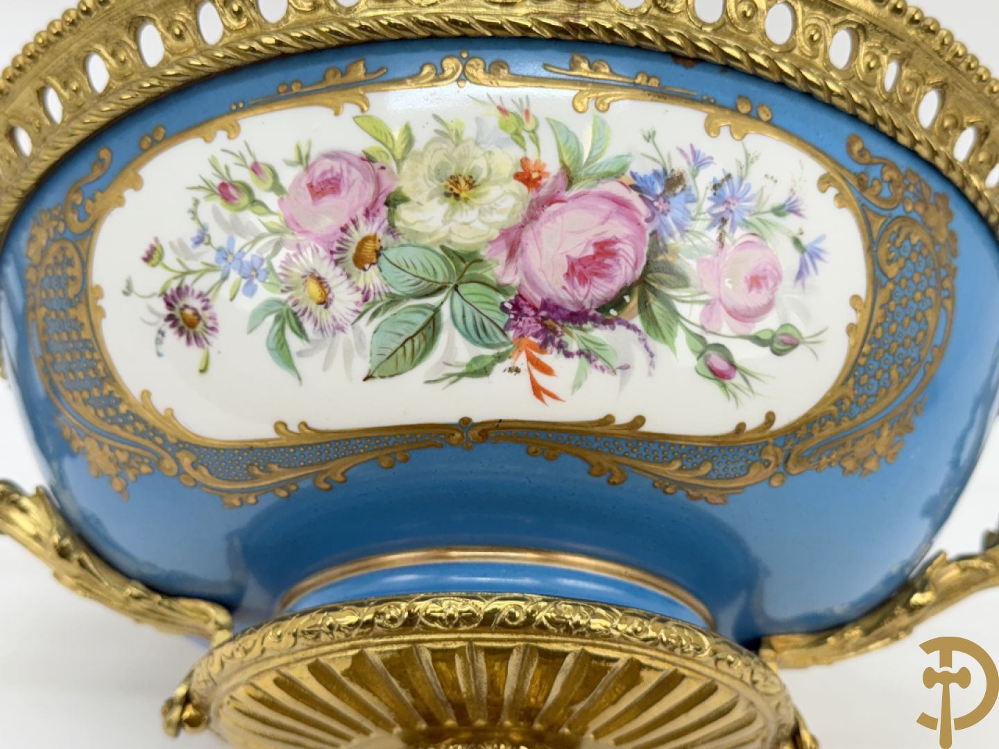 Porseleinen coupe met centraal tafereel en omringd met bloemendecor, gevat in bronzen houder