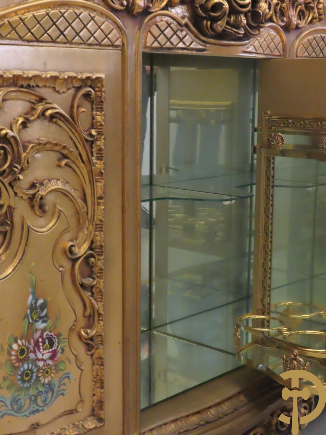 Uitzonderlijke vergulde Louis XV eetkamer bestaande uit vijfdeursdressoir met voluutvormige accanthusranken en rocailles, beschilderd met bloemenmotieven en centraal tafererel met hoornen des overvloeds + bijhorende spiegel vergulde tafel op voluutvormige poten met zes bijhorende stoelen + vitrine met accanthusranken en centrale deur, op voluutvormige poten