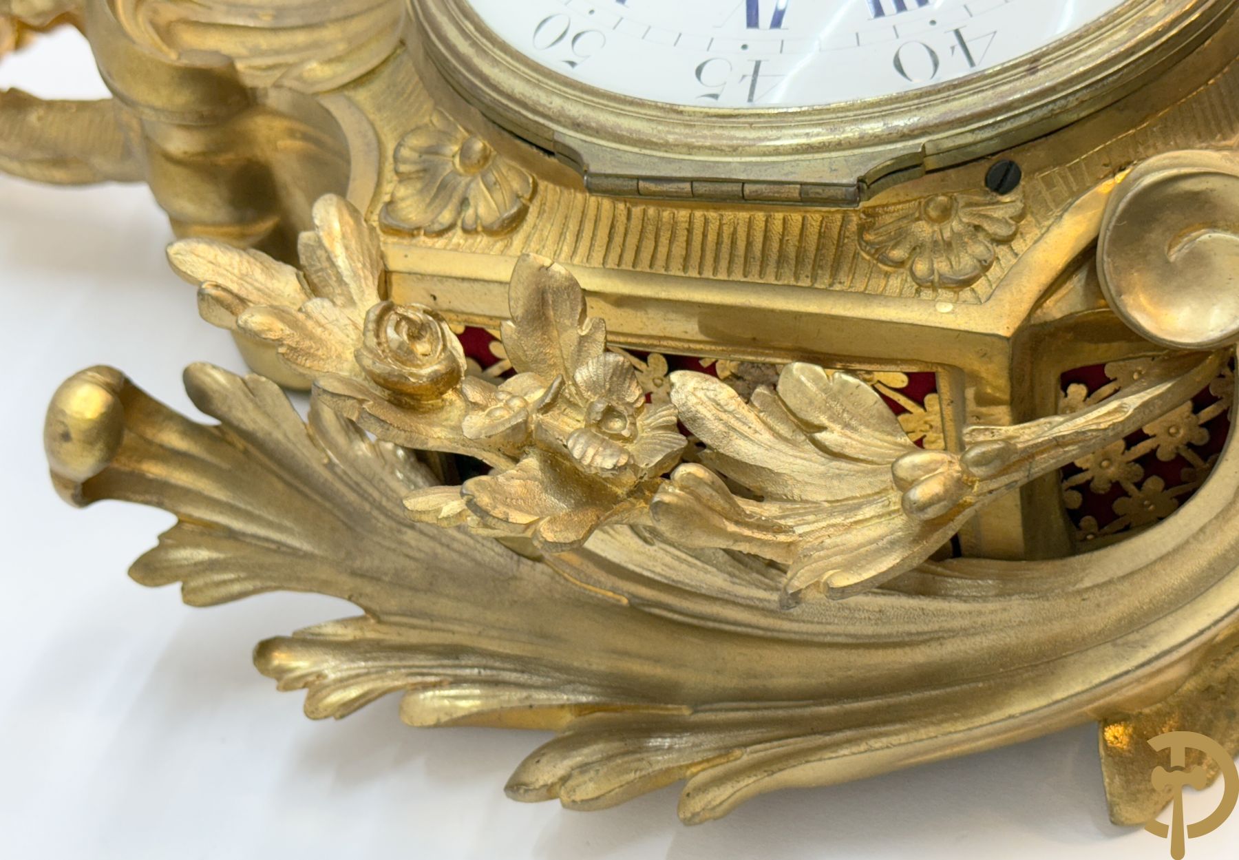 Bronzen muurkartel Louis XV stijl met bloemenmotieven en bovenaan bezet met faune met triangle, Molle Paris getekend binnenin op uurwerk