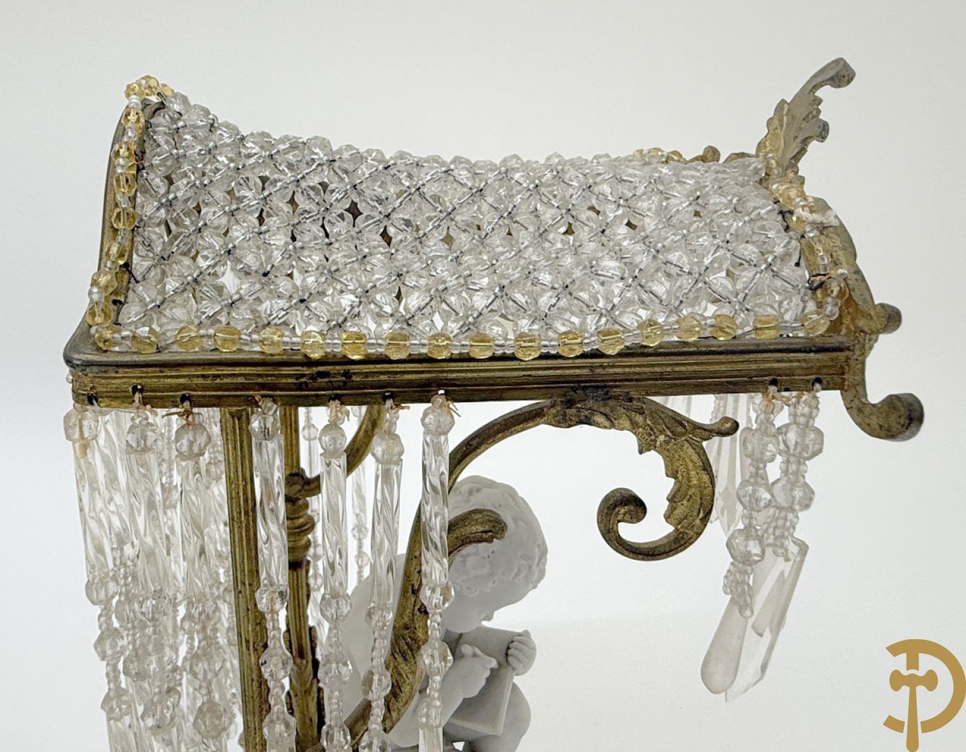 Biscuitbeeld van schrijvende cupido onder bronzen dakje met kristallen bellen bezet - op marmeren sokkel gemonteerd