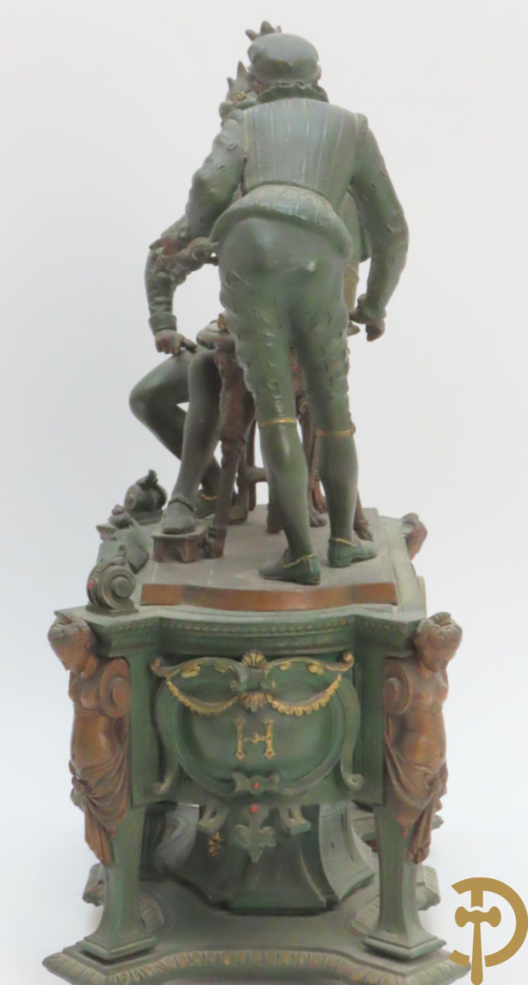 Driedelige kunstbronzen garnituur bestaande uit pendule met paar schakende edelheren, bezet met kariatiden - geflankeerd door paar driearmige kandelaars gehouden door 2 edelheren