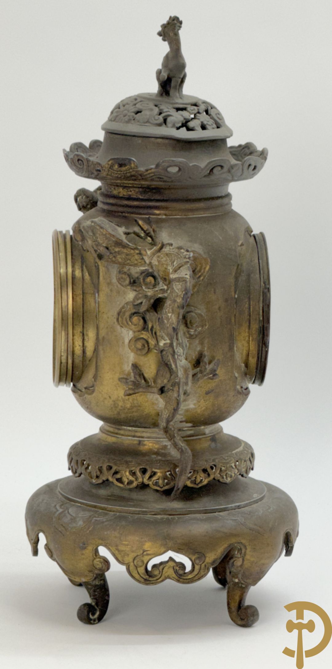 Aziatische pendule in zamak, zijdelings bezet met drakendecor en bovenaan met mythologisch figuur