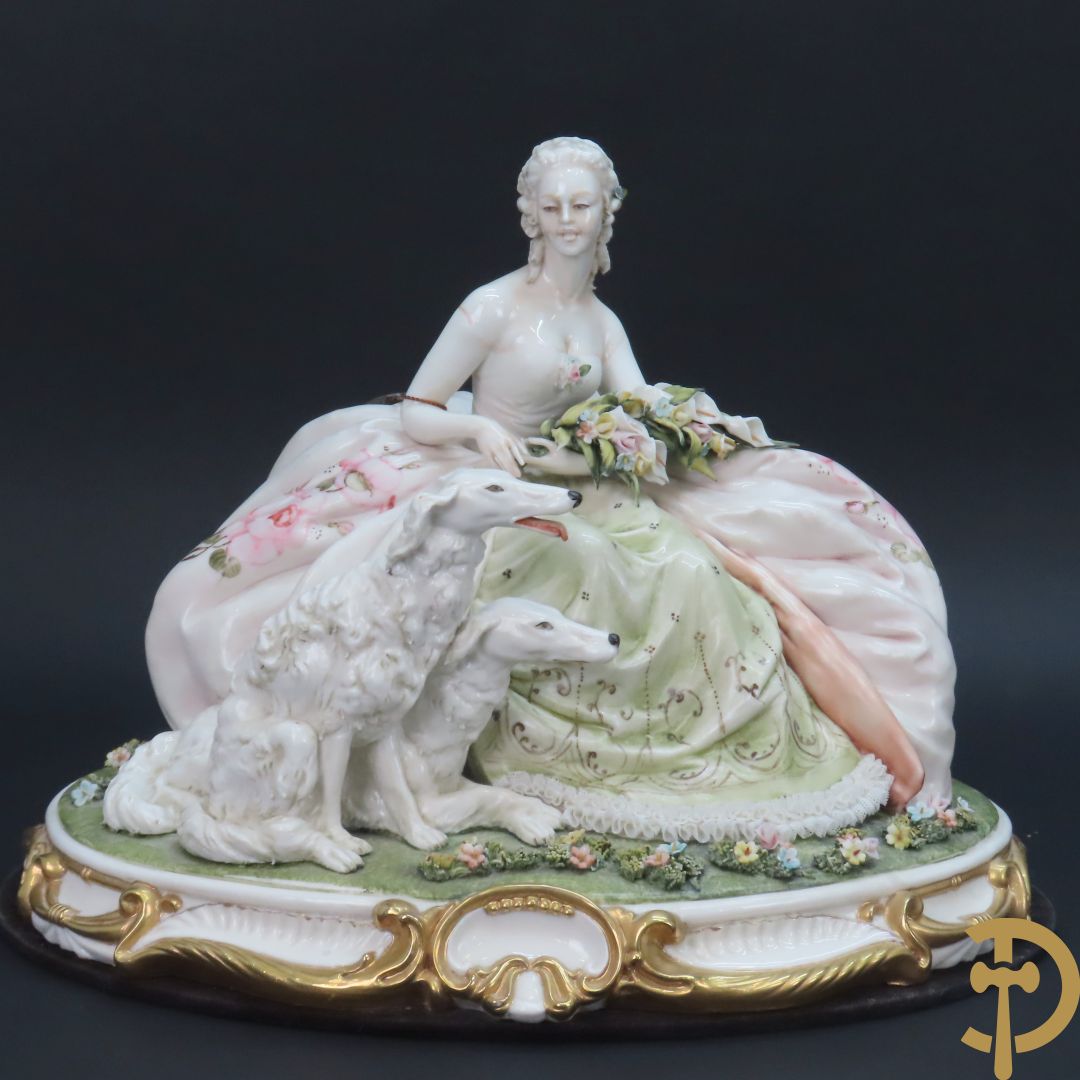 Italiaans porseleinen sierbeeld van zittende dame met 2 windhonden, L. Cazzola getekend en Capo di Monte gemerkt achteraan