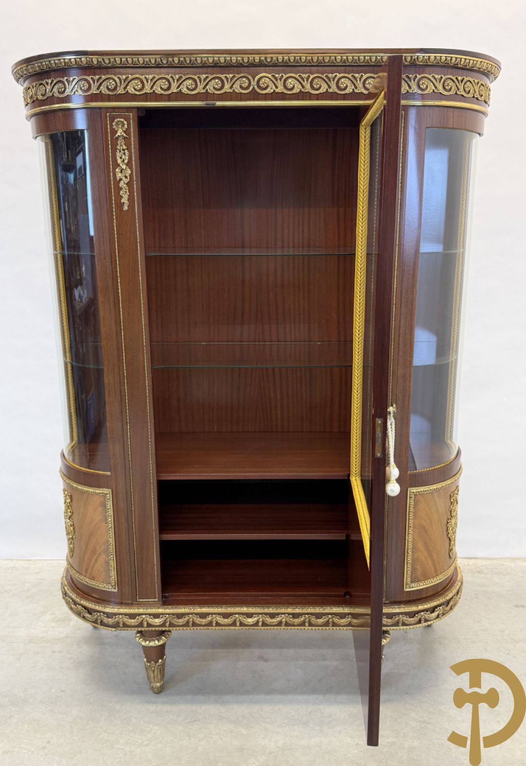 Notelaren vitrine met afgeronde zijkanten, bezet met bronzen plakkettes van dame en cupido