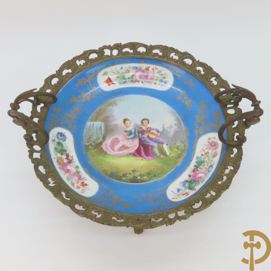 Porseleinen Sèvres schotel met handbeschilderd romantisch tafereel van lieflijk koppel gevat in bronzen houder - bezet met dameshoofden en accanthusranken, onderaan gemerkt Sèvres