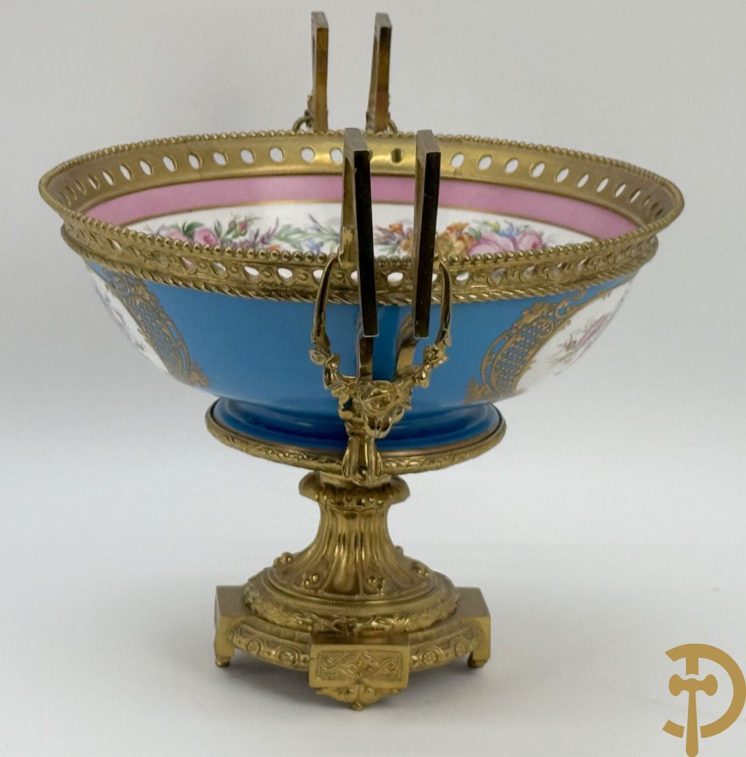 Porseleinen coupe met centraal tafereel en omringd met bloemendecor, gevat in bronzen houder