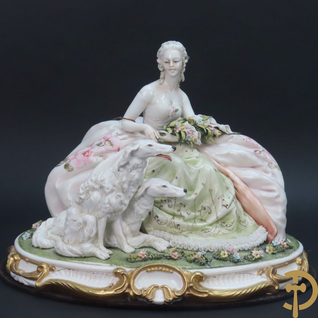 Italiaans porseleinen sierbeeld van zittende dame met 2 windhonden, L. Cazzola getekend en Capo di Monte gemerkt achteraan