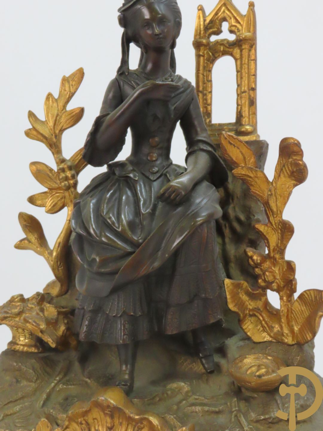 Bronzen pendule bezet met elegante dame en onderaan met basrelief en rocailles