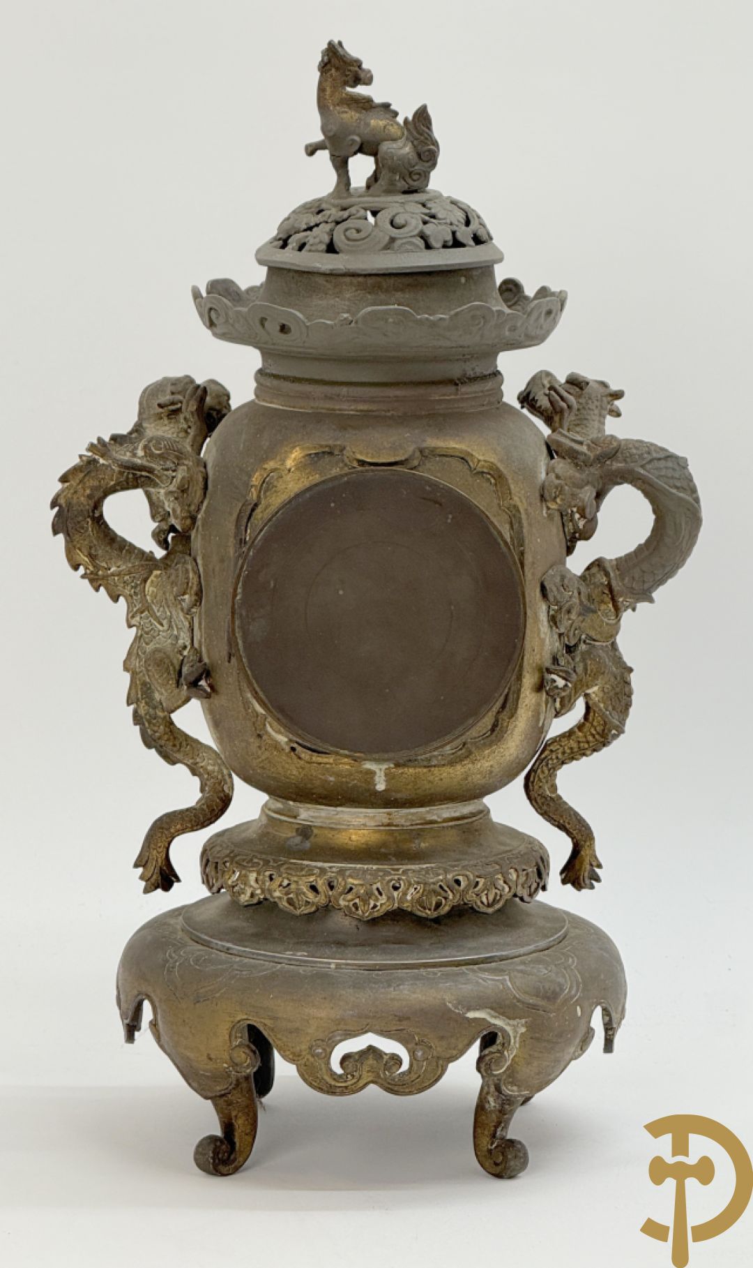 Aziatische pendule in zamak, zijdelings bezet met drakendecor en bovenaan met mythologisch figuur