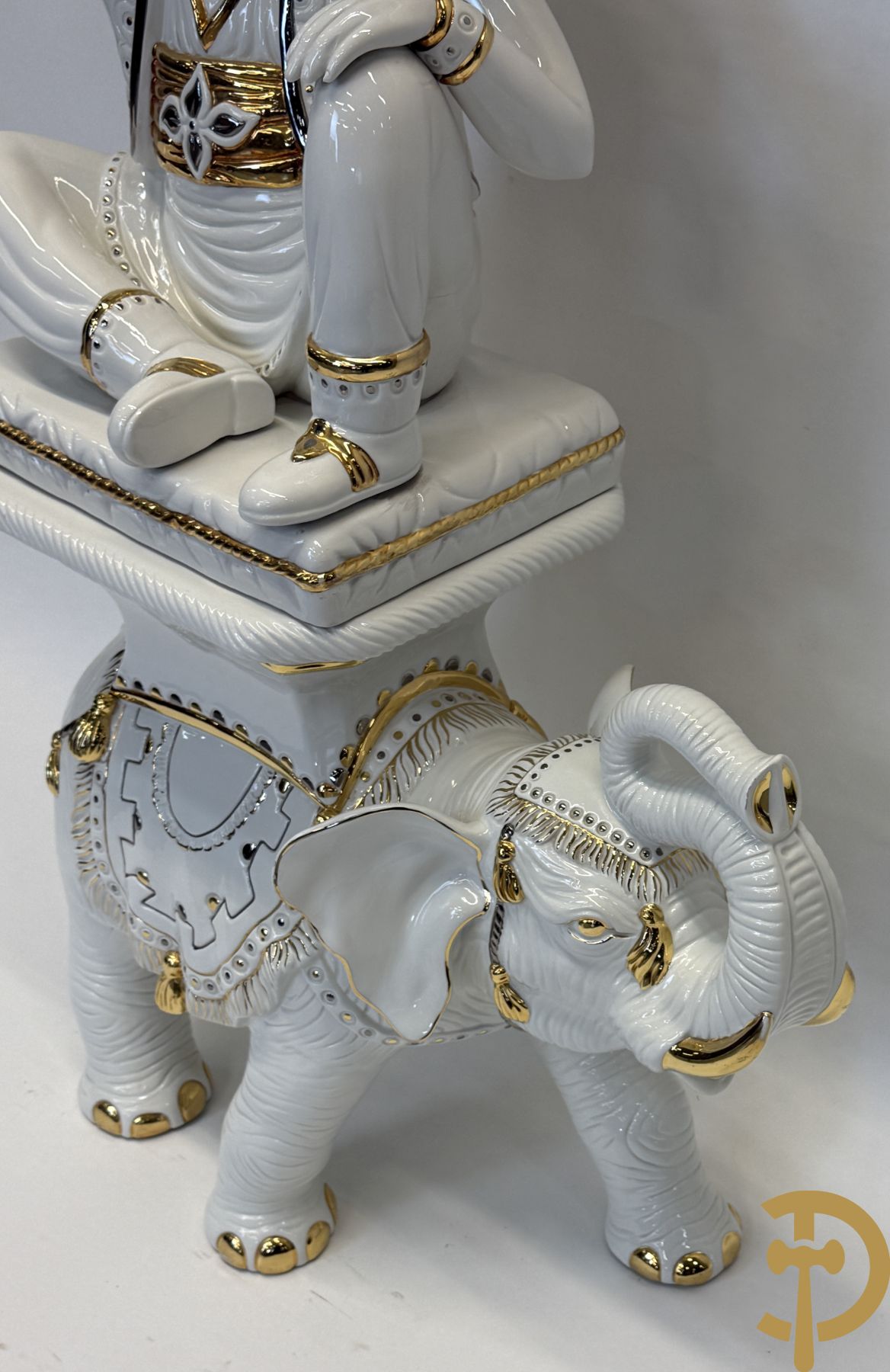 Porseleinen sierbeeld van olifant als staander met daarboven jongeman met bloemencachepot