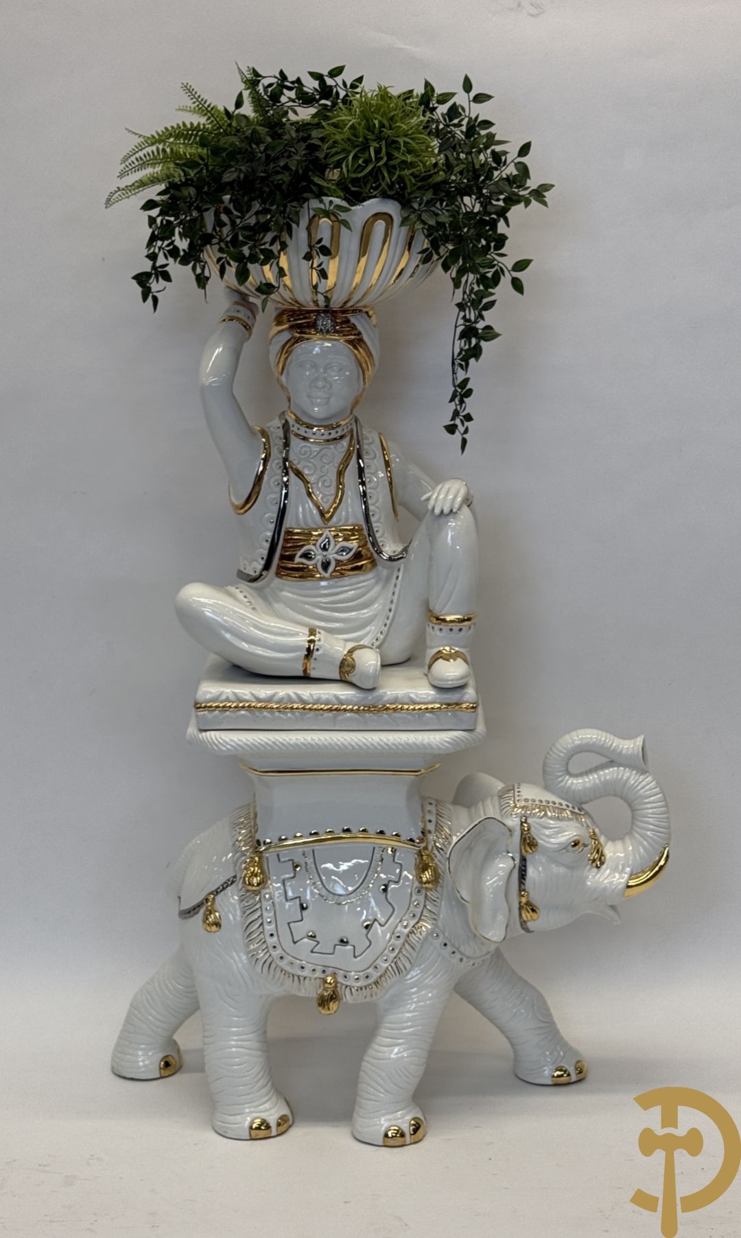 Porseleinen sierbeeld van olifant als staander met daarboven jongeman met bloemencachepot