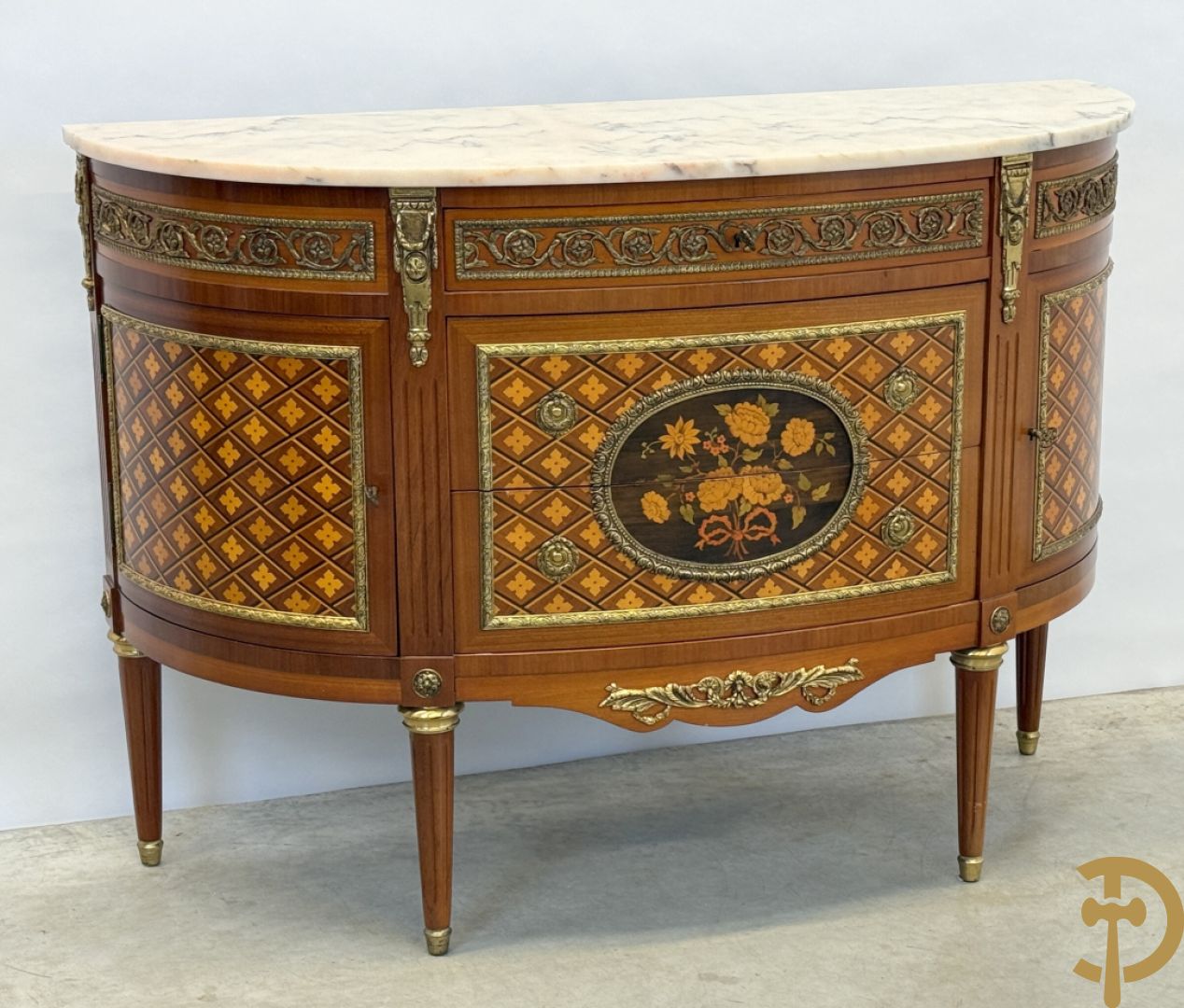 Halve maanvormige drieladencommode met 2 zijdelingse deuren, gemarketteerde bloemenmotieven en bronzen ornamenten, bovenaan bezet met marmeren blad