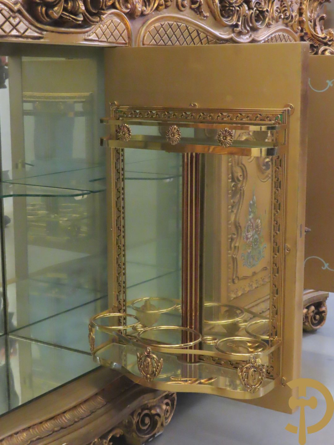 Uitzonderlijke vergulde Louis XV eetkamer bestaande uit vijfdeursdressoir met voluutvormige accanthusranken en rocailles, beschilderd met bloemenmotieven en centraal tafererel met hoornen des overvloeds + bijhorende spiegel vergulde tafel op voluutvormige poten met zes bijhorende stoelen + vitrine met accanthusranken en centrale deur, op voluutvormige poten