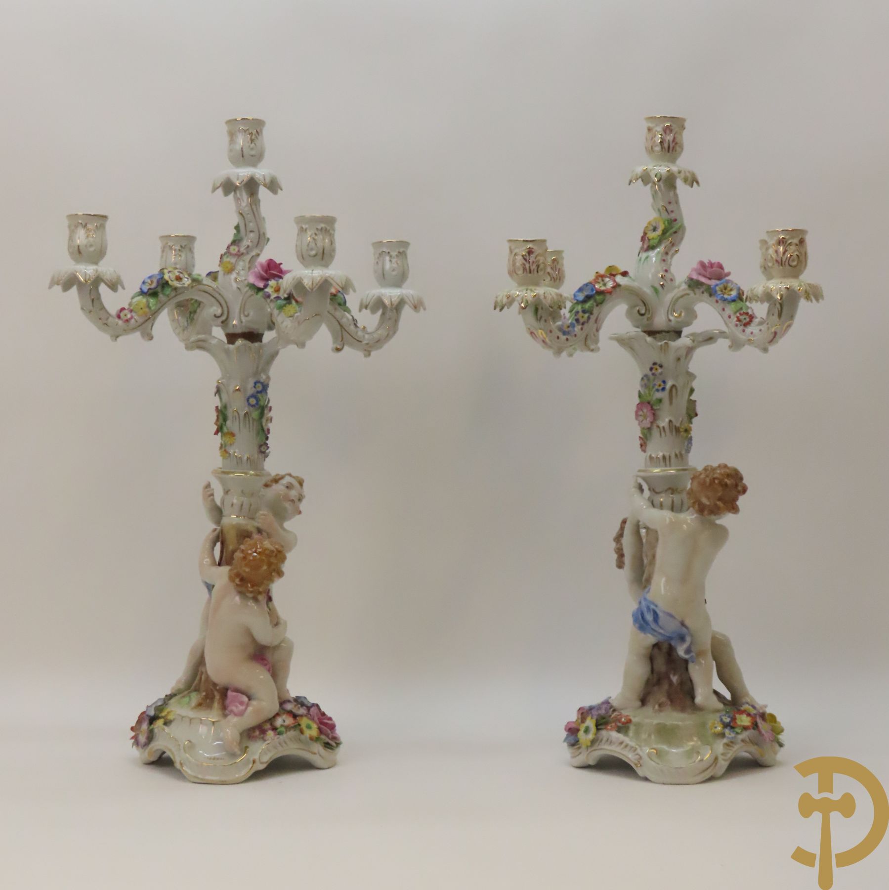 Twee porseleinen vijfarmige kandelaars met cupido