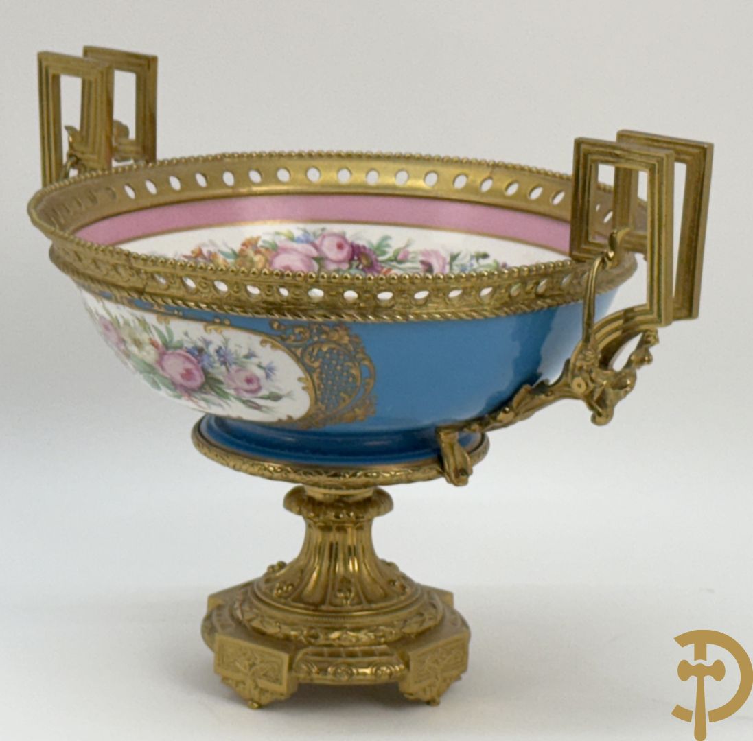 Porseleinen coupe met centraal tafereel en omringd met bloemendecor, gevat in bronzen houder