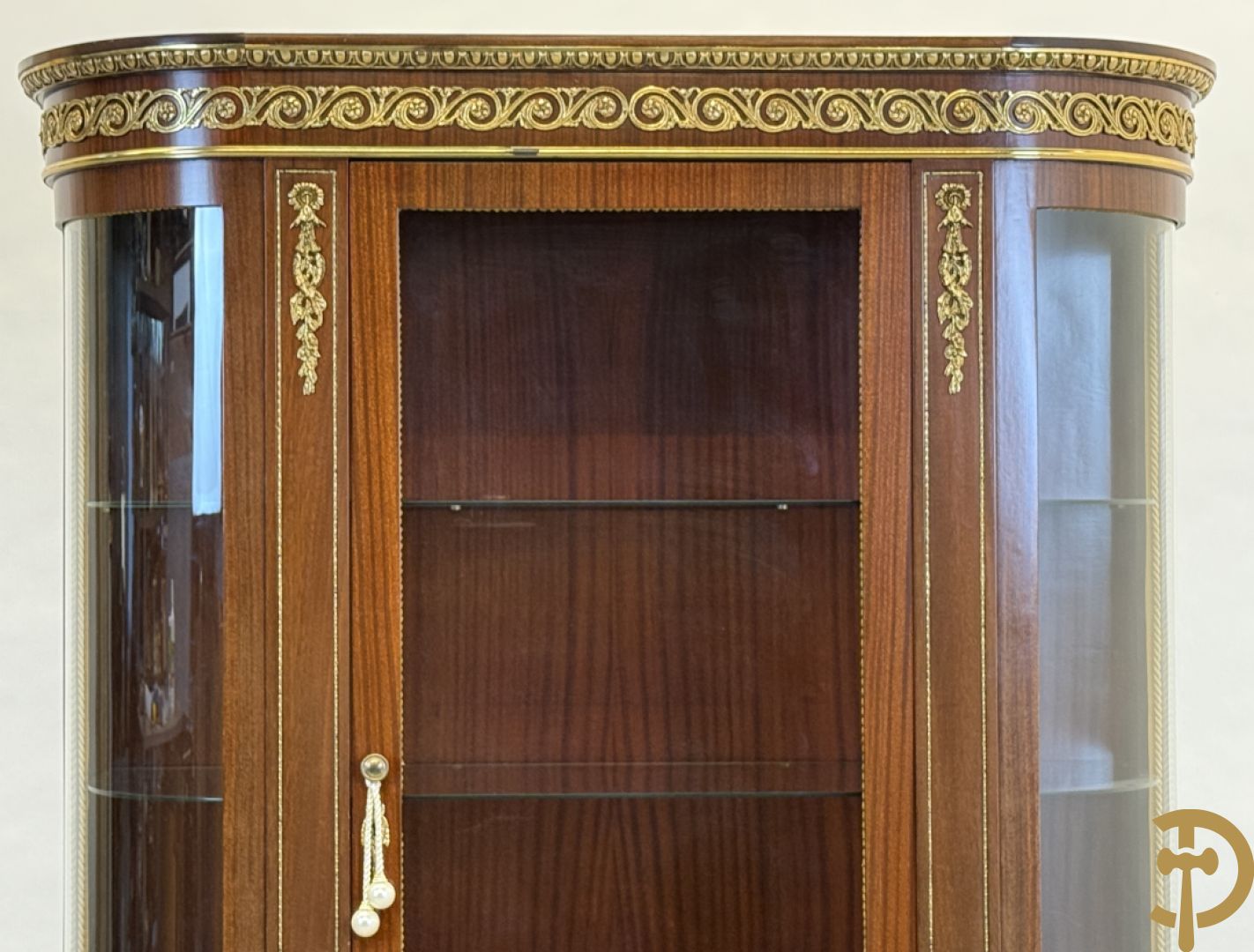 Notelaren vitrine met afgeronde zijkanten, bezet met bronzen plakkettes van dame en cupido