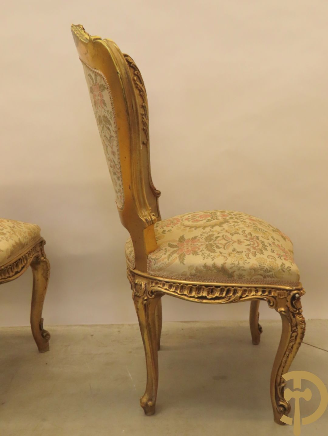 Uitzonderlijke vergulde Louis XV eetkamer bestaande uit vijfdeursdressoir met voluutvormige accanthusranken en rocailles, beschilderd met bloemenmotieven en centraal tafererel met hoornen des overvloeds + bijhorende spiegel vergulde tafel op voluutvormige poten met zes bijhorende stoelen + vitrine met accanthusranken en centrale deur, op voluutvormige poten