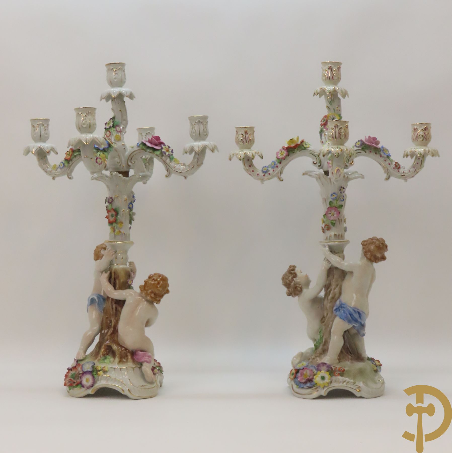 Twee porseleinen vijfarmige kandelaars met cupido