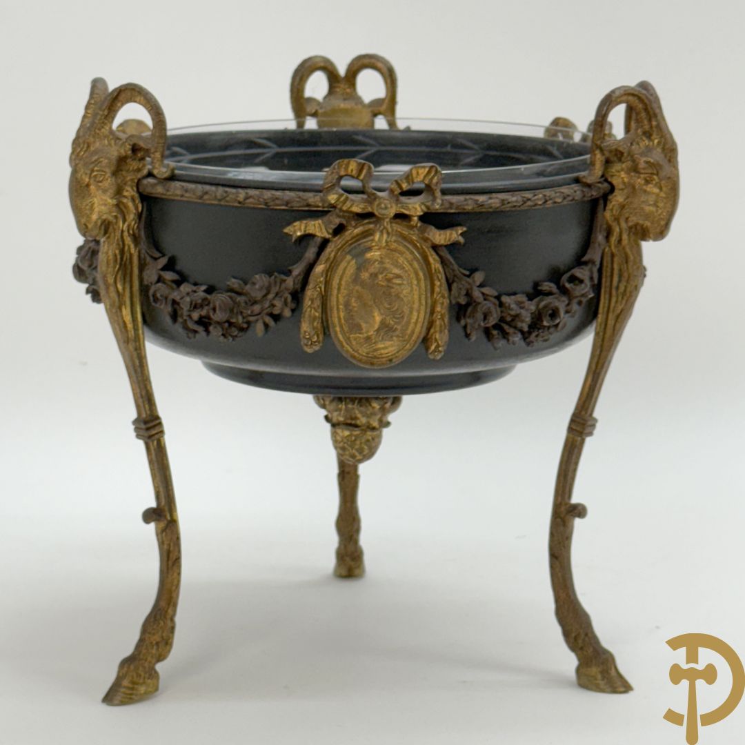 Bronzen coupe op 3 bokkepoten met ramskoppen  bezet en verbonden door guirlandes met medaillon