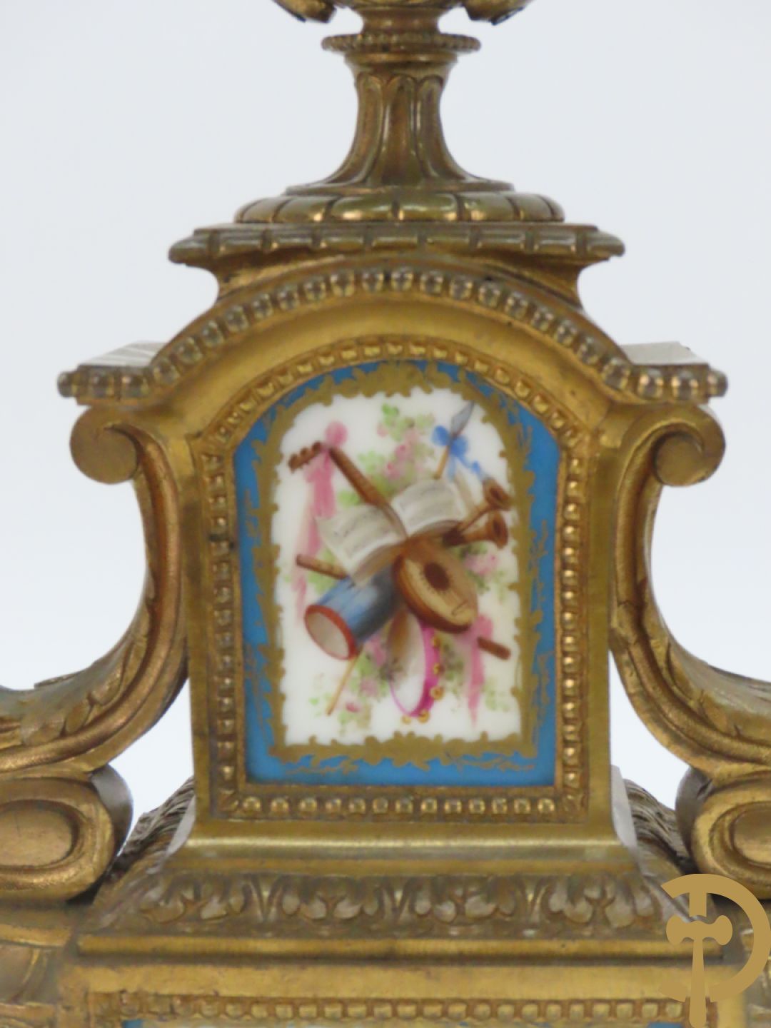 Driedelige bronzen garnituur bezet met Sèvres porselein bestaande uit pendule geflankeerd door paar cupido