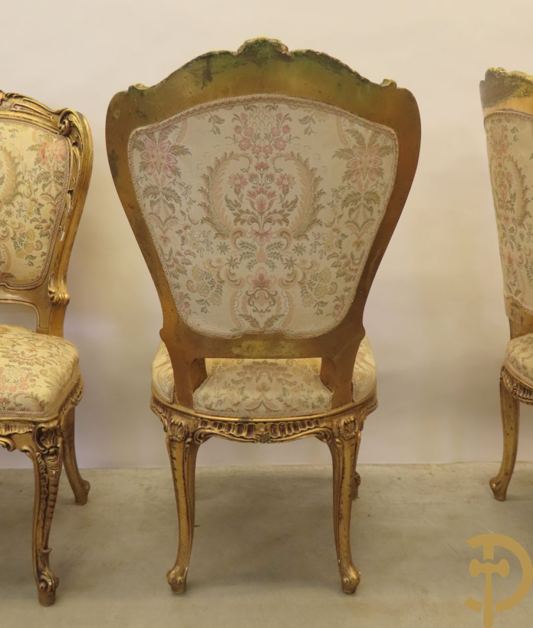Uitzonderlijke vergulde Louis XV eetkamer bestaande uit vijfdeursdressoir met voluutvormige accanthusranken en rocailles, beschilderd met bloemenmotieven en centraal tafererel met hoornen des overvloeds + bijhorende spiegel vergulde tafel op voluutvormige poten met zes bijhorende stoelen + vitrine met accanthusranken en centrale deur, op voluutvormige poten