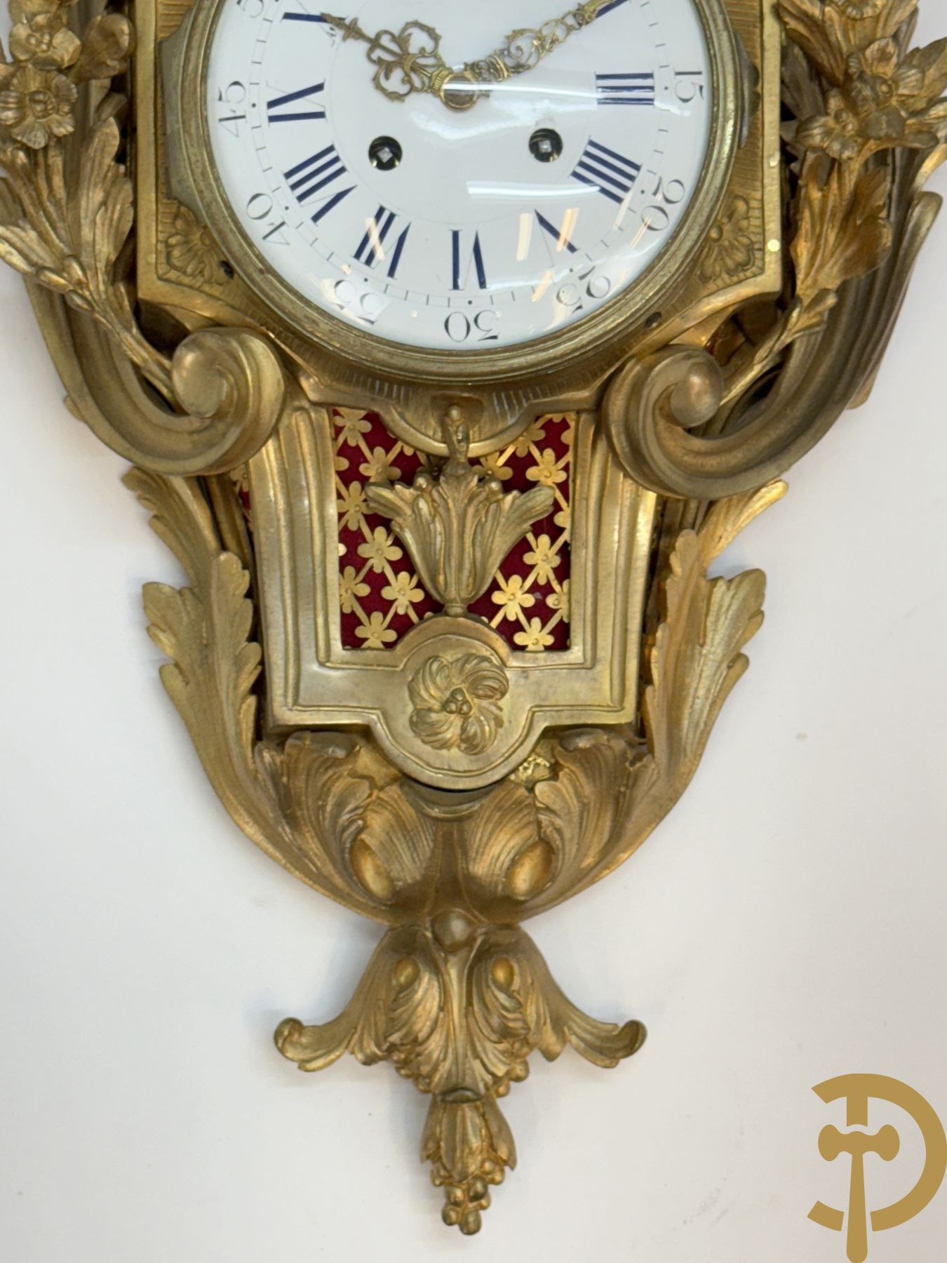 Bronzen muurkartel Louis XV stijl met bloemenmotieven en bovenaan bezet met faune met triangle, Molle Paris getekend binnenin op uurwerk