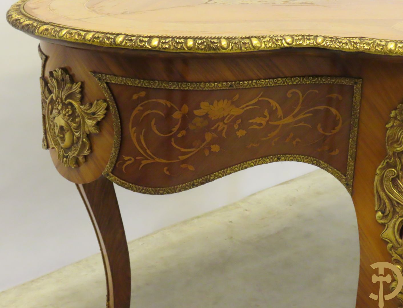 Gemarketteerde ovale notelaren tafel bezet met bronsbeslag van dameshoofden + stoel