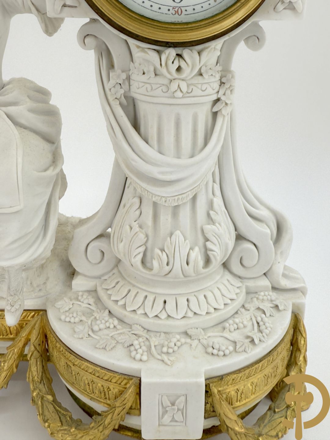 Driedelige porseleinen garnituur met bronsbeslag bestaande uit pendule met dame en amfoor geflankeerd door paar kandelaars bezet met personages