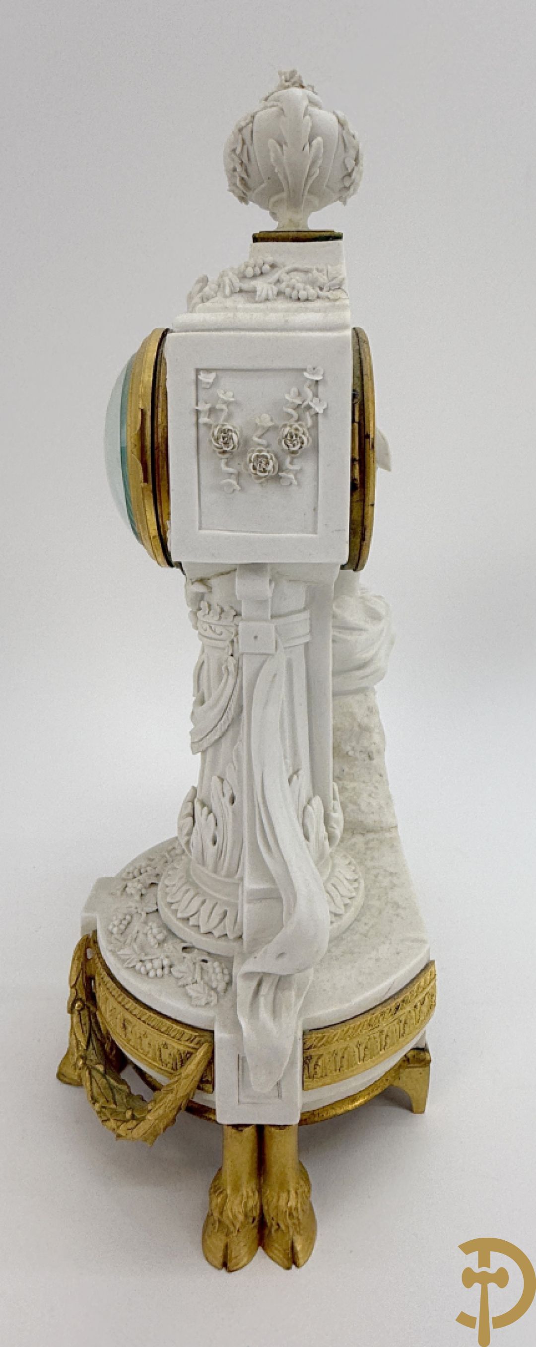 Driedelige porseleinen garnituur met bronsbeslag bestaande uit pendule met dame en amfoor geflankeerd door paar kandelaars bezet met personages