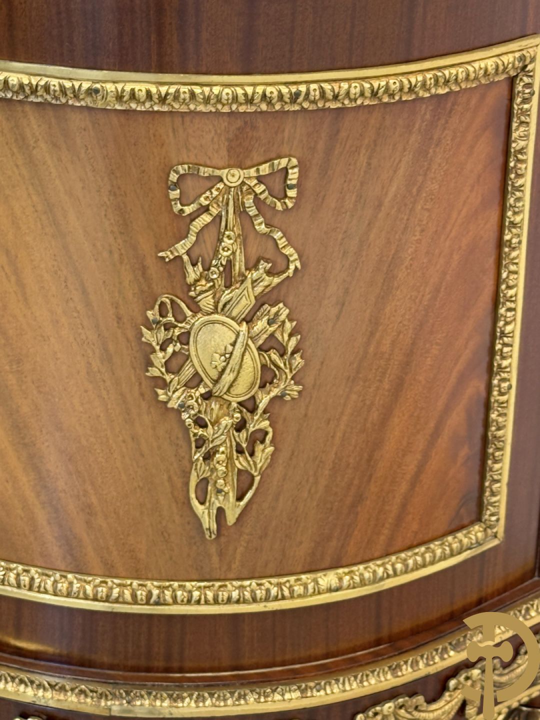 Notelaren vitrine met afgeronde zijkanten, bezet met bronzen plakkettes van dame en cupido