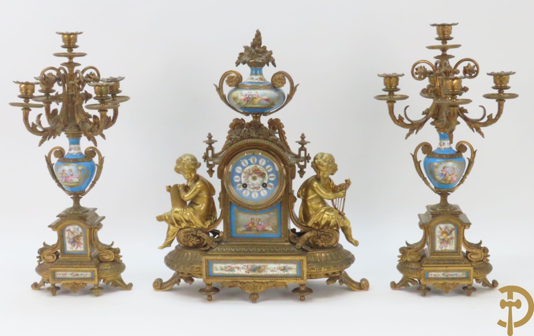 Driedelige bronzen garnituur bezet met Sèvres porselein bestaande uit pendule geflankeerd door paar cupido