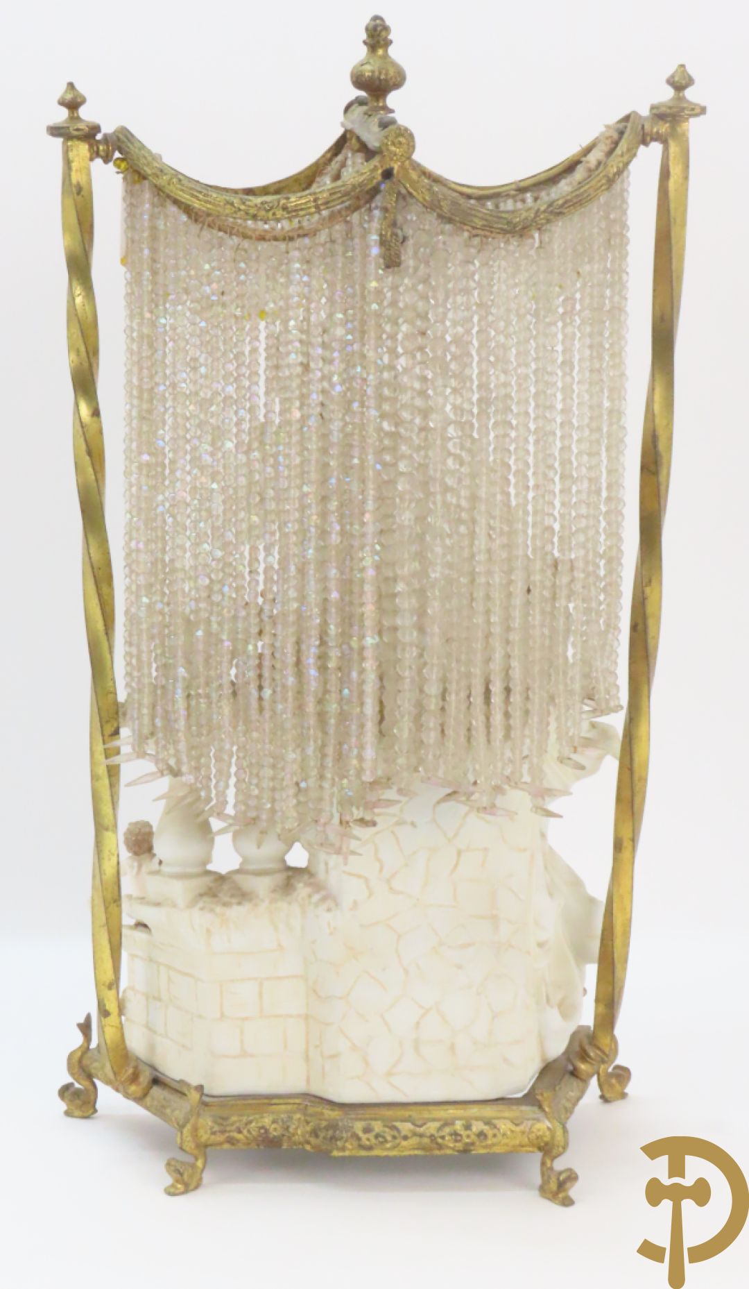 Lieftallig biscuit van romantisch koppel bij amfoor met kleine neergezeten cupido onder koperen baldakijn met kristallen belletjes