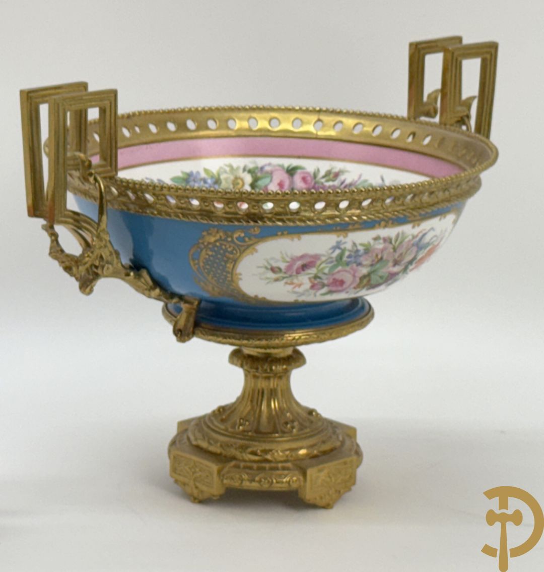 Porseleinen coupe met centraal tafereel en omringd met bloemendecor, gevat in bronzen houder