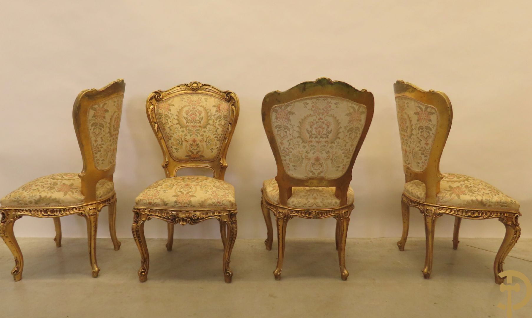 Uitzonderlijke vergulde Louis XV eetkamer bestaande uit vijfdeursdressoir met voluutvormige accanthusranken en rocailles, beschilderd met bloemenmotieven en centraal tafererel met hoornen des overvloeds + bijhorende spiegel vergulde tafel op voluutvormige poten met zes bijhorende stoelen + vitrine met accanthusranken en centrale deur, op voluutvormige poten