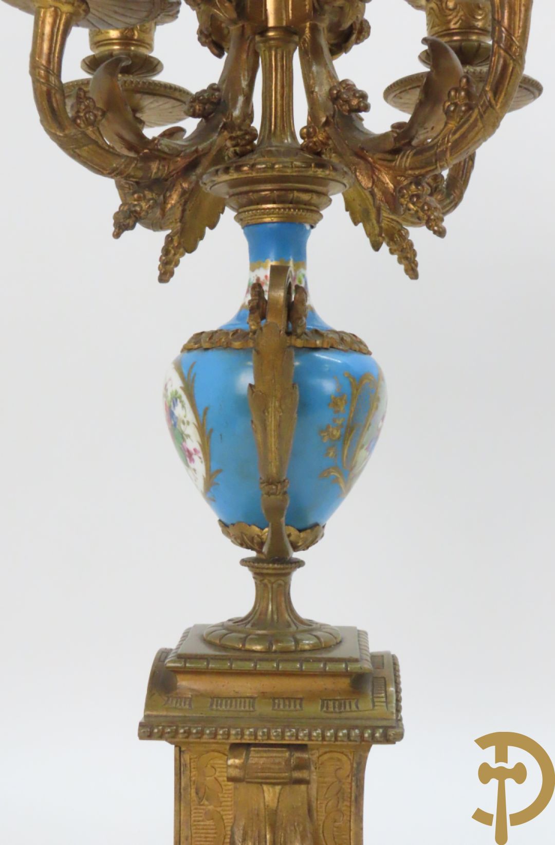 Driedelige bronzen garnituur bezet met Sèvres porselein bestaande uit pendule geflankeerd door paar cupido