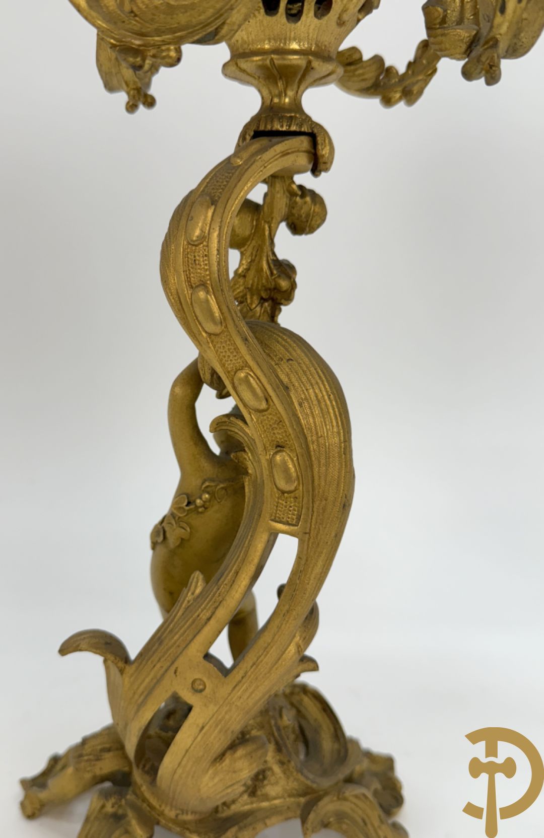 Driedelige vuurvergulde bronzen garnituur, Louis XV stijl, bestaande uit middenstuk met klok omgeven door musicerende cupido