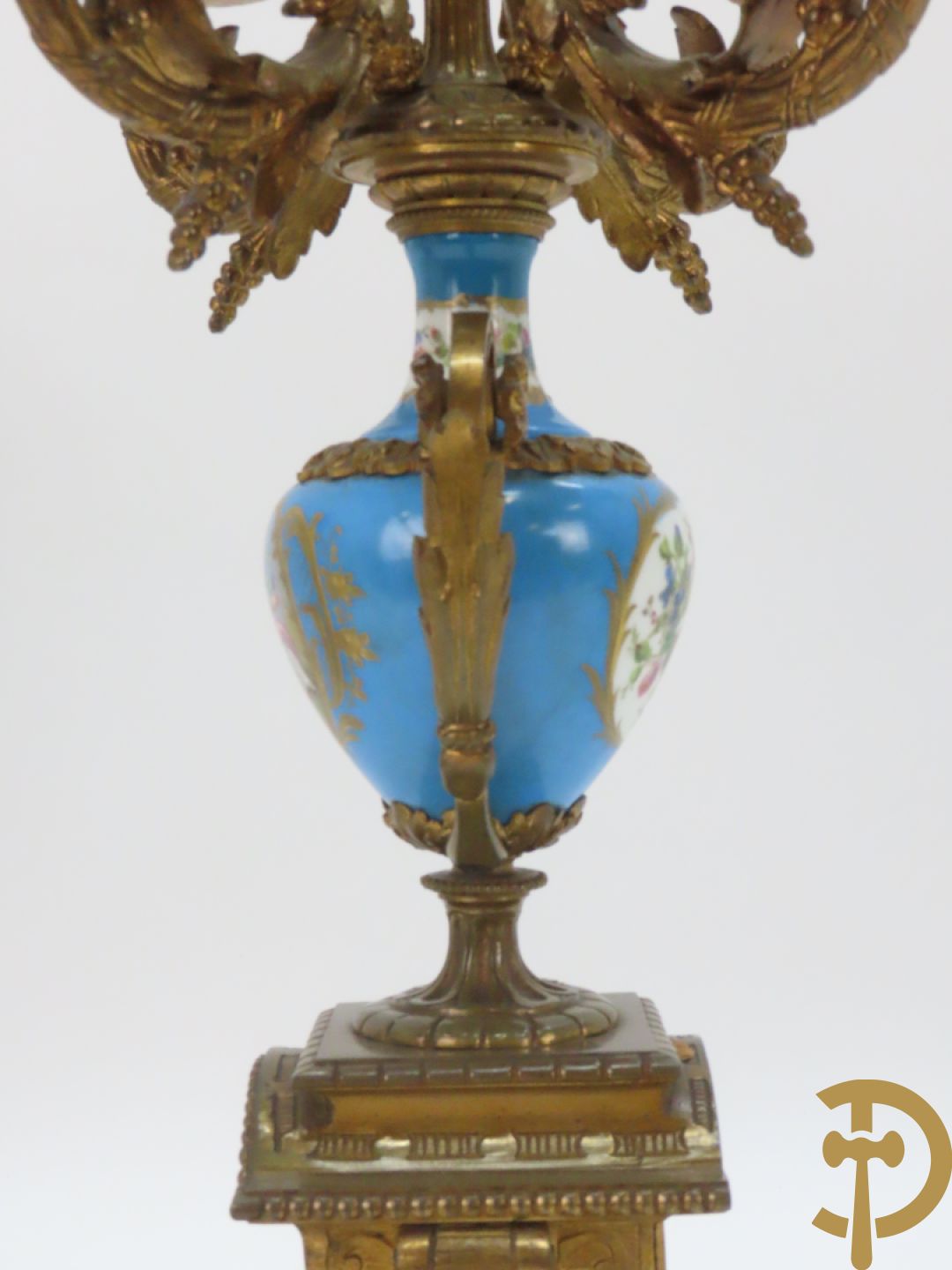 Driedelige bronzen garnituur bezet met Sèvres porselein bestaande uit pendule geflankeerd door paar cupido