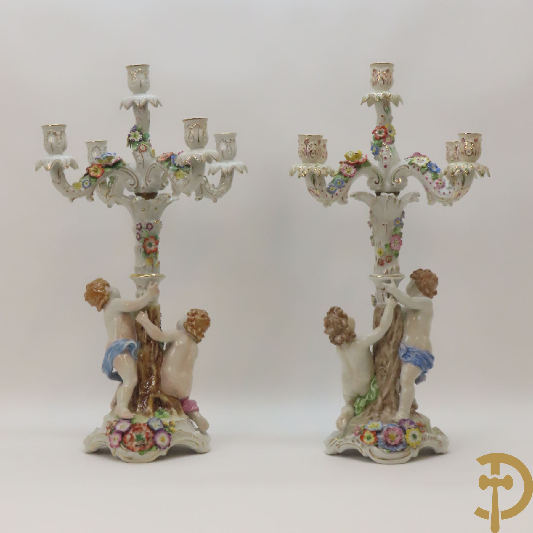 Twee porseleinen vijfarmige kandelaars met cupido