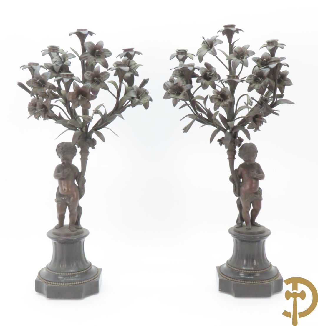 CLODION getekend - Paar elegante bronzen dames met tambour en fruit, geflankeerde door jonge faune, op marmeren klokstel - opgebouwd als garnituur met 2 kandelaars met bronzen kindjes dragende een toorts met bloemen en kaarsen