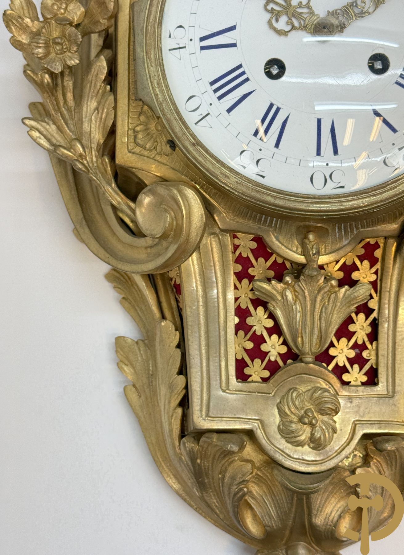 Bronzen muurkartel Louis XV stijl met bloemenmotieven en bovenaan bezet met faune met triangle, Molle Paris getekend binnenin op uurwerk