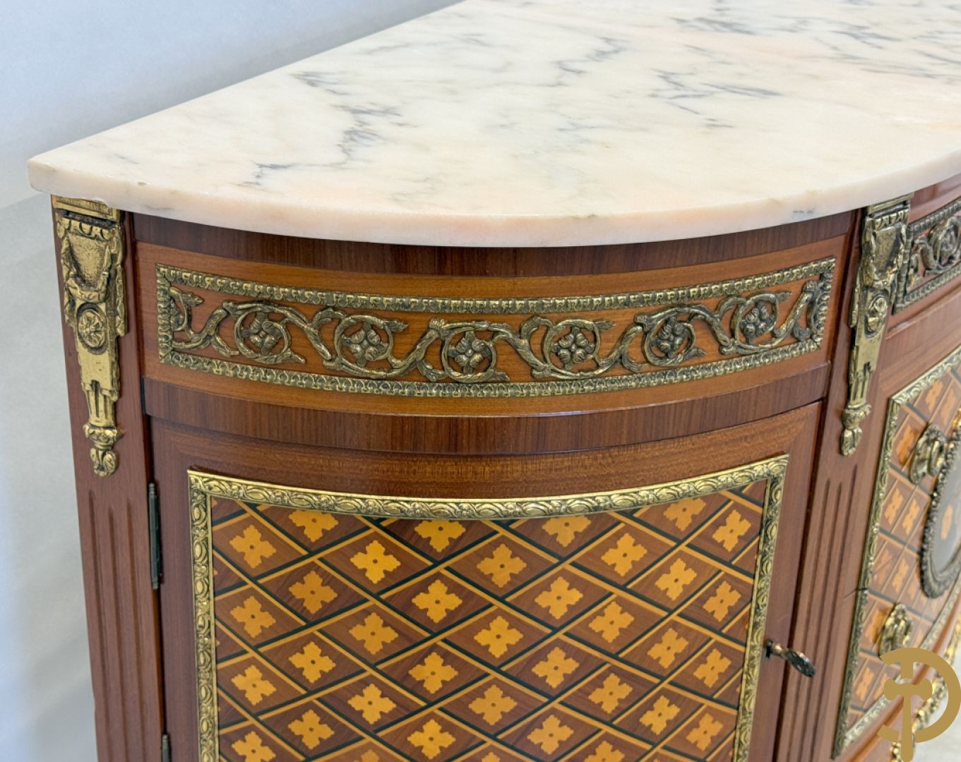 Halve maanvormige drieladencommode met 2 zijdelingse deuren, gemarketteerde bloemenmotieven en bronzen ornamenten, bovenaan bezet met marmeren blad