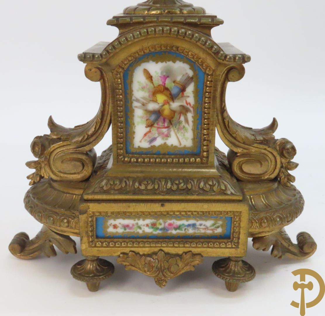 Driedelige bronzen garnituur bezet met Sèvres porselein bestaande uit pendule geflankeerd door paar cupido