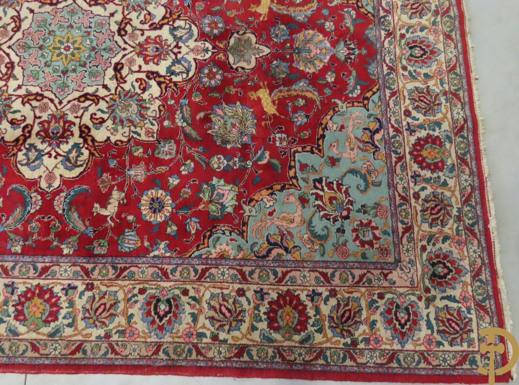 Oosters handgeknoopt tapijt met bloemen, dierenmotieven en centraal decor op rode fond