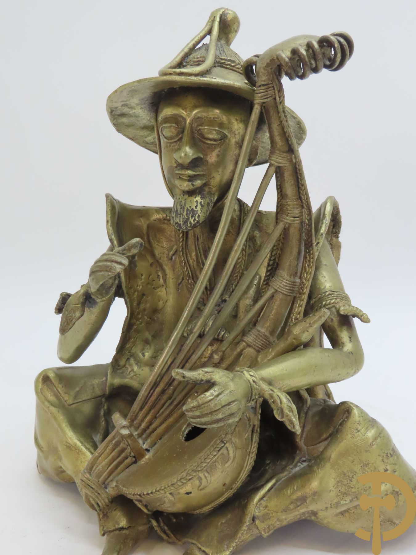 Balinese bronssculptuur van zittende man met snaarinstrument